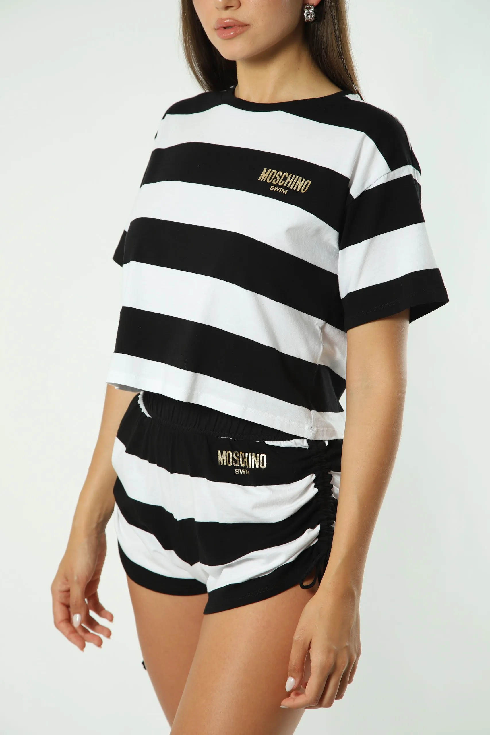 Camiseta bicolor de rayas blancas y negras con minilogo dorado